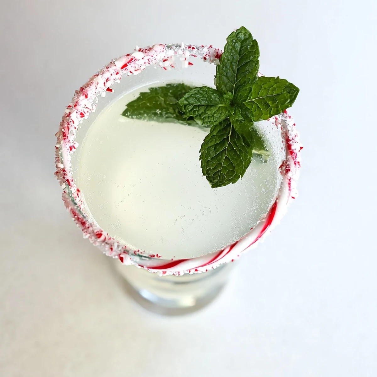 Vibrant Peppermint Drop cocktail, a bright, festive drink garnished with mint and sugared rim.