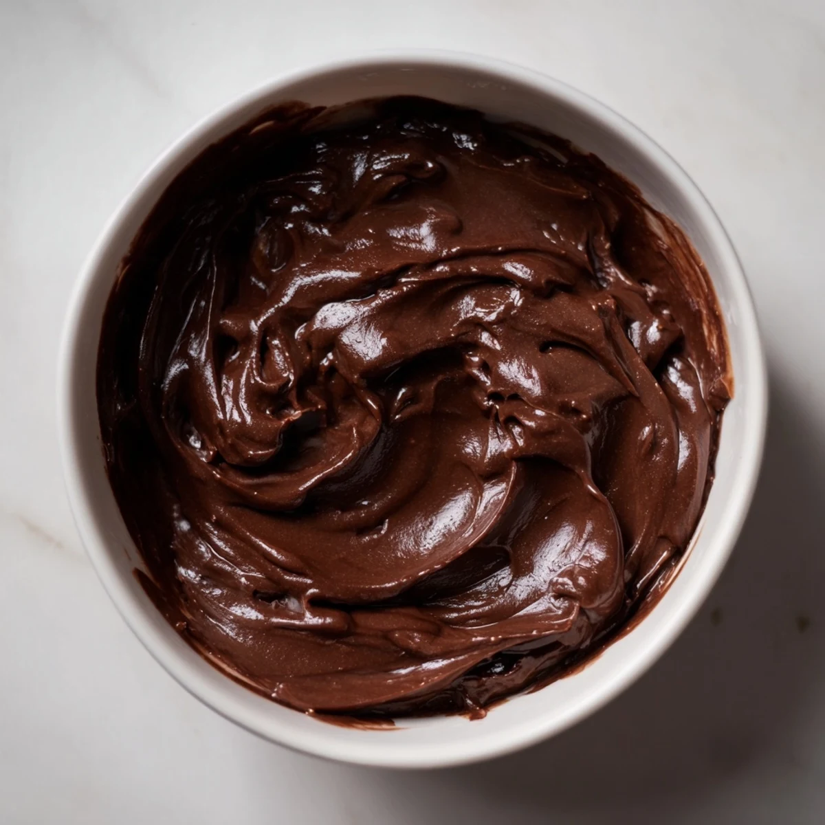 Silky-smooth homemade chocolate spread, ready to be drizzled over fluffy pancakes for breakfast.