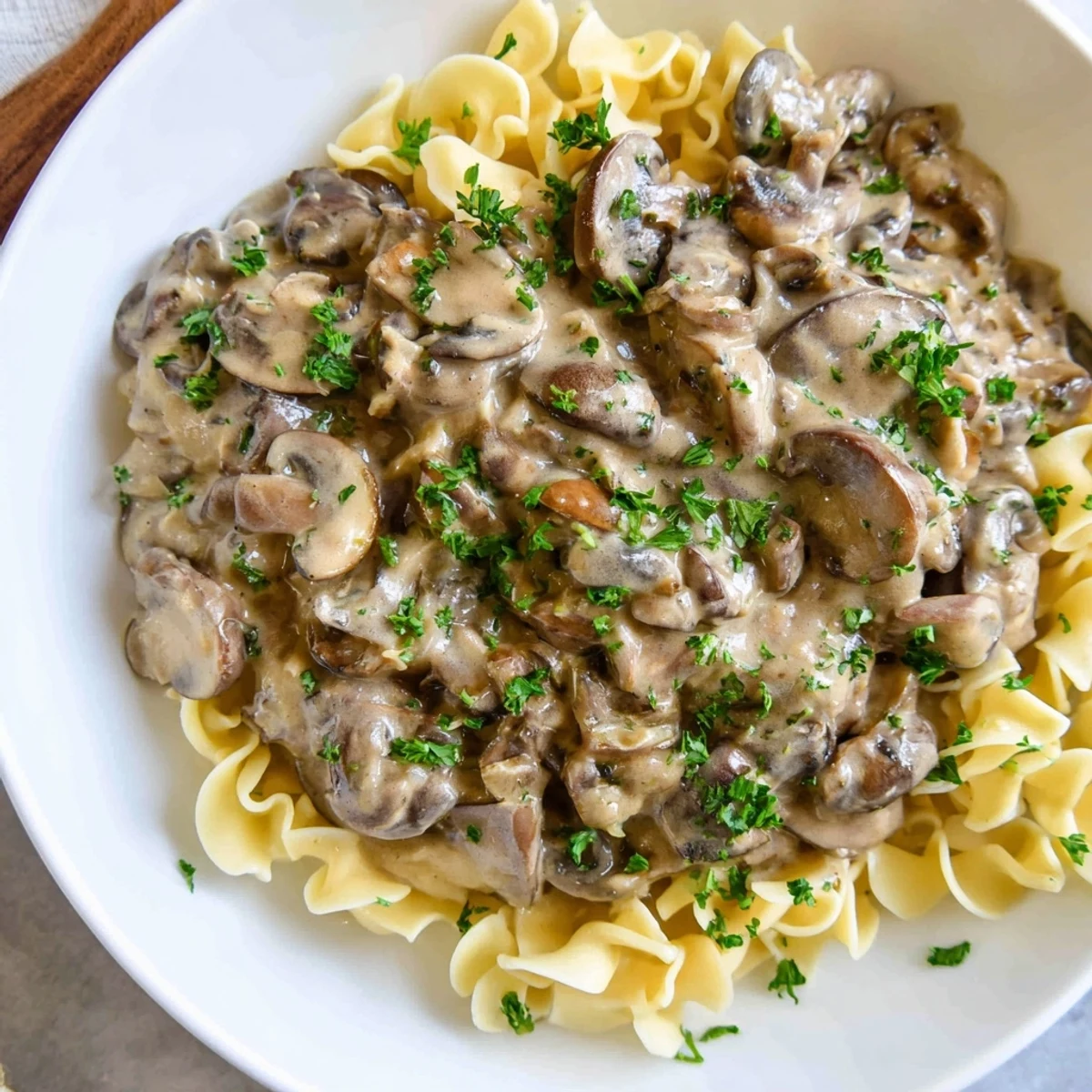 A hearty serving of Creamy Mushroom Stroganoff with fresh parsley, perfect for a cozy vegetarian dinner.