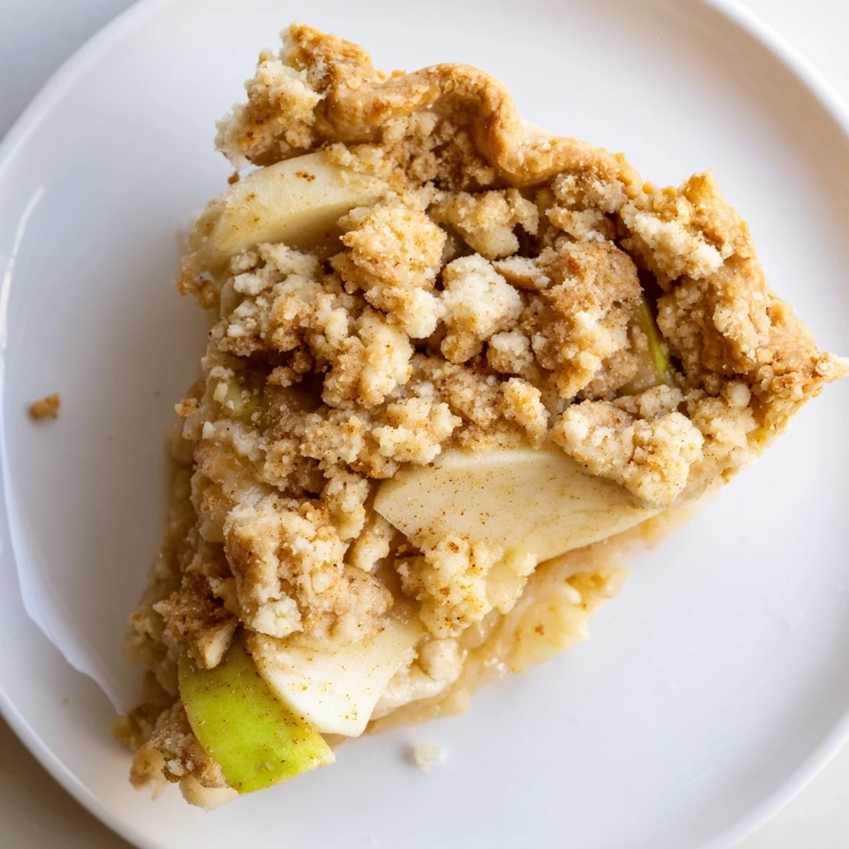 A close-up of a rustic Cinnamon Apple Crumble Pie, showcasing a perfect buttery crumble topping and warm filling.