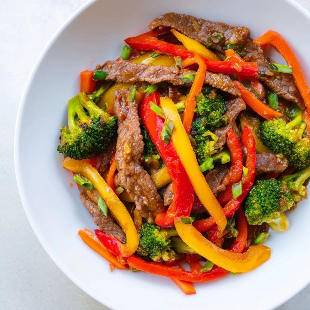 Tender beef stir fry with colorful vegetables glistening in a savory, glossy sauce, ready to serve.