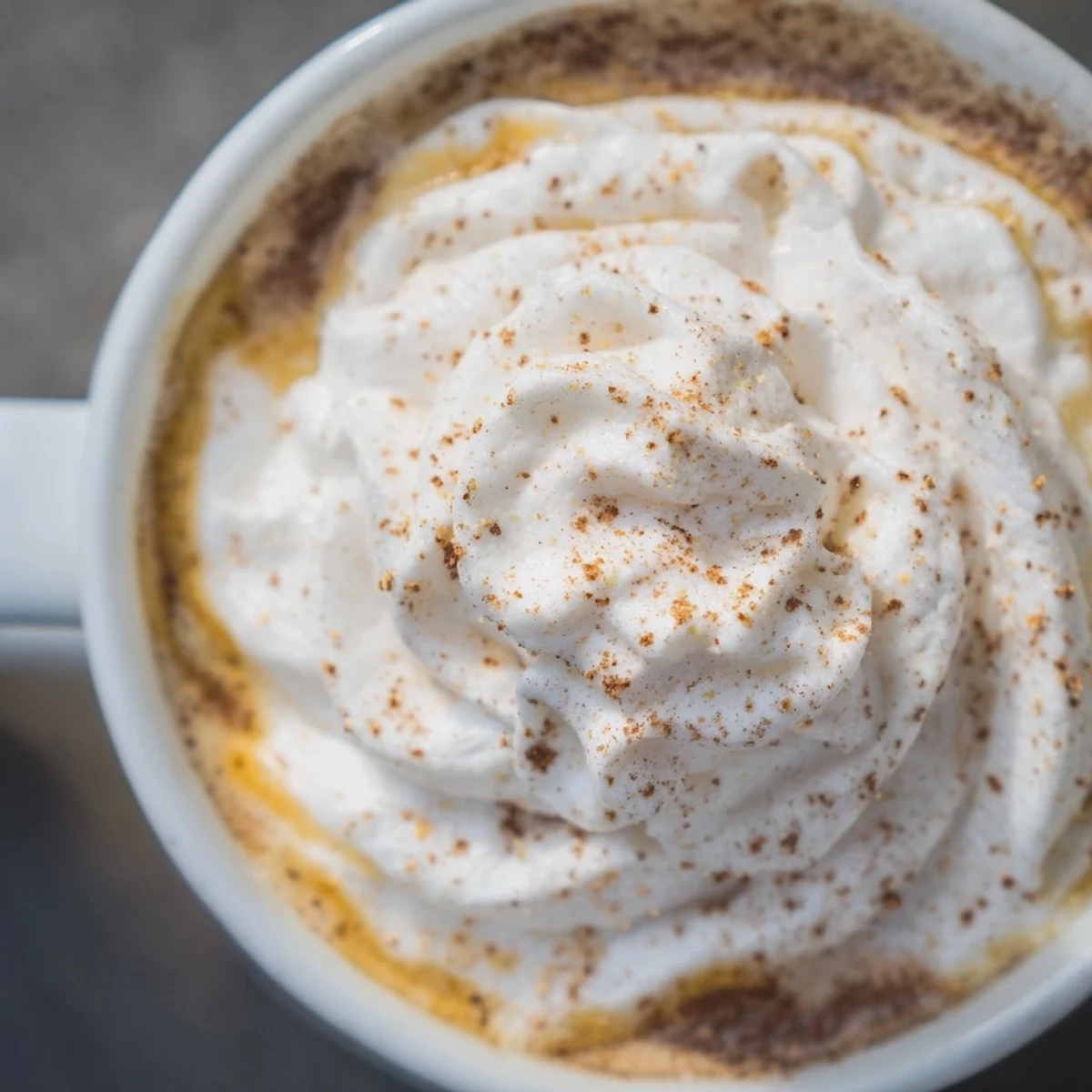 A close-up of a warm Gingerbread Latte in a mug, showcasing the frothy milk and spices.