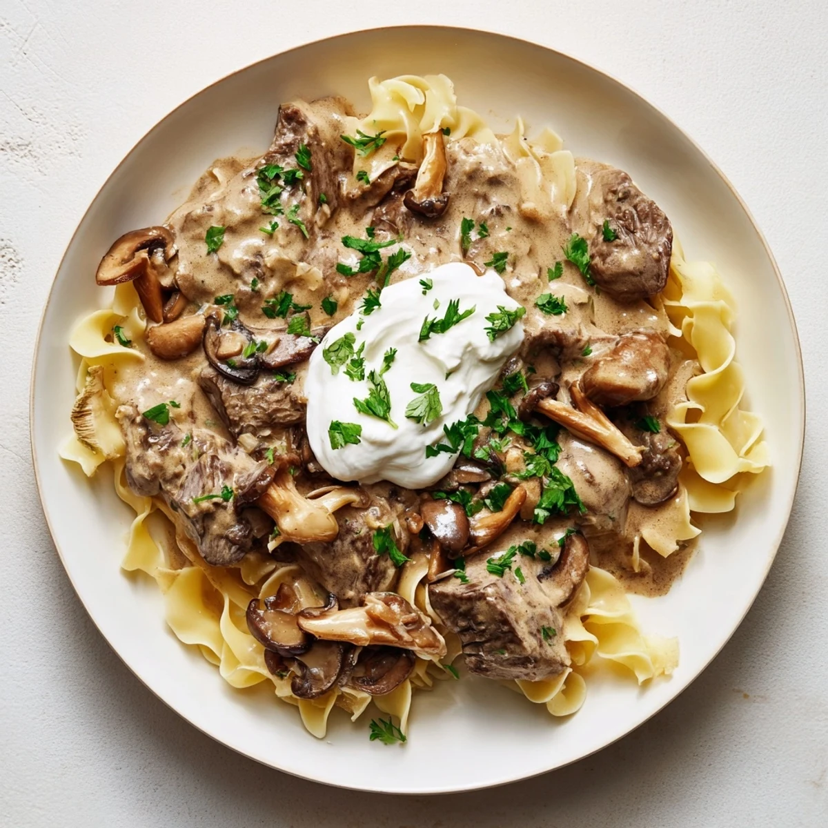 Tender beef stroganoff with wild mushrooms, a creamy sauce, and fresh parsley garnish.