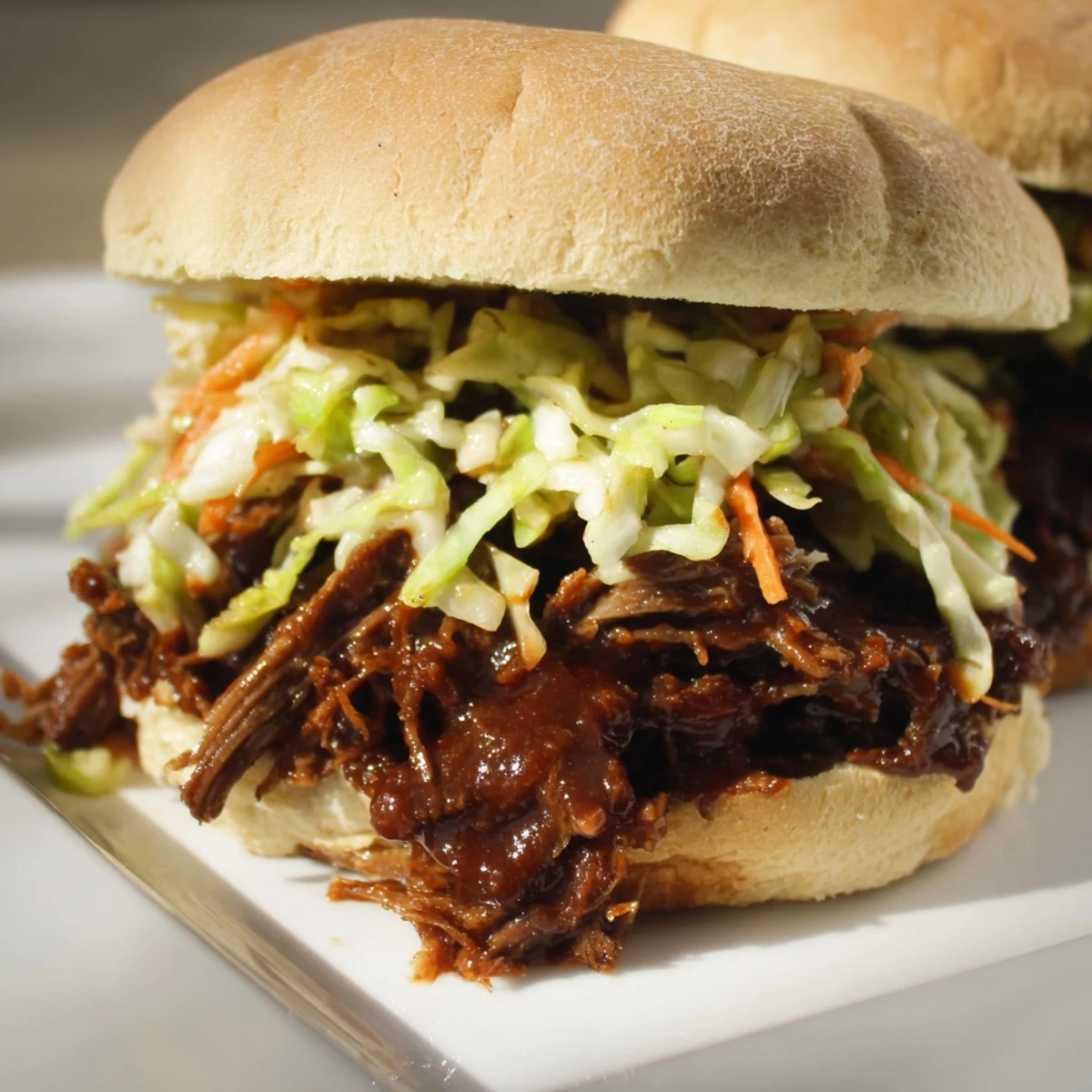 Hearty Slow Cooker Pulled Beef Sandwiches featuring juicy shredded meat and tangy slaw, ready for a backyard game day feast.
