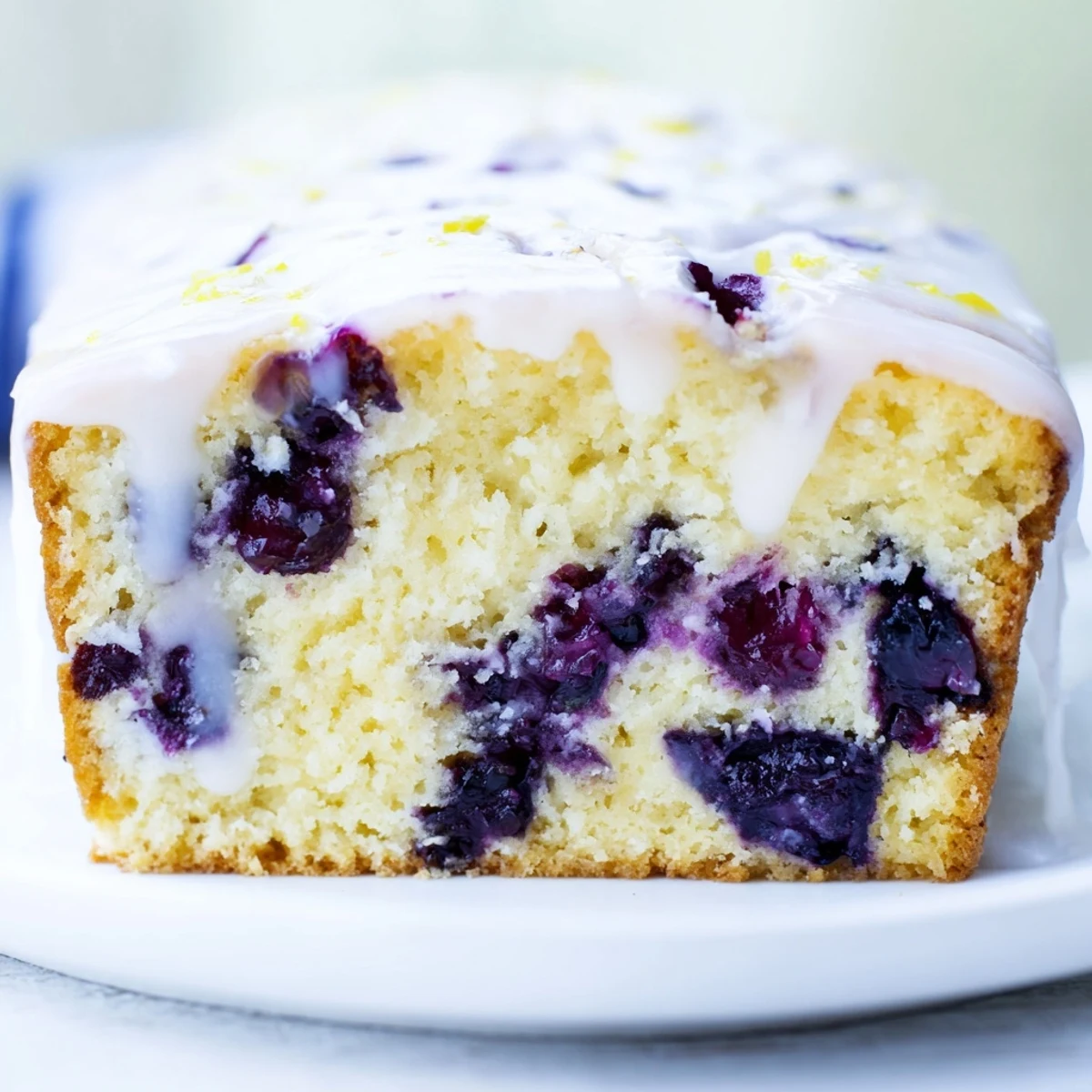 A close-up of Lemon and Blueberry Yogurt Loaf showing tender crumb and juicy blueberries, perfect for breakfast or afternoon tea.