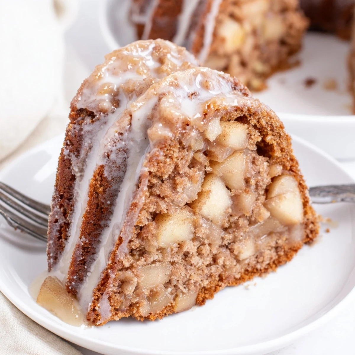 Homemade Spiced Apple Cider Bundt Cake on a rustic table, served with vanilla ice cream for autumn gatherings.