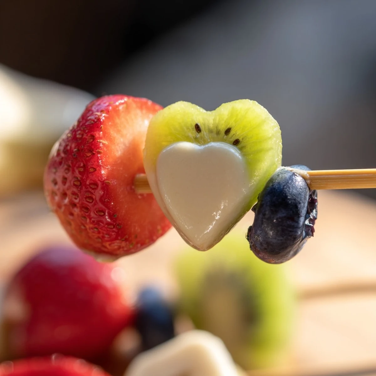 Sweetheart Fruit Kabobs with Yogurt Dip showcase vibrant strawberries, kiwi, and pineapple chunks on skewers beside a creamy honey-sweetened dip.