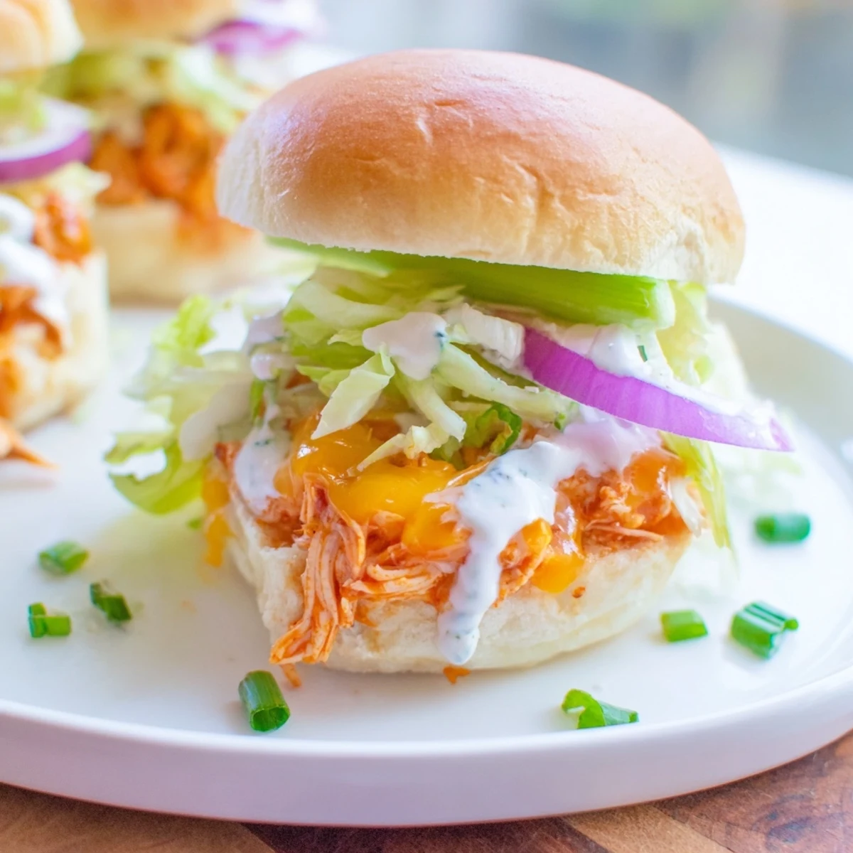 Soft slider buns loaded with spicy buffalo chicken, crisp lettuce, and creamy ranch dressing, perfect for game day.