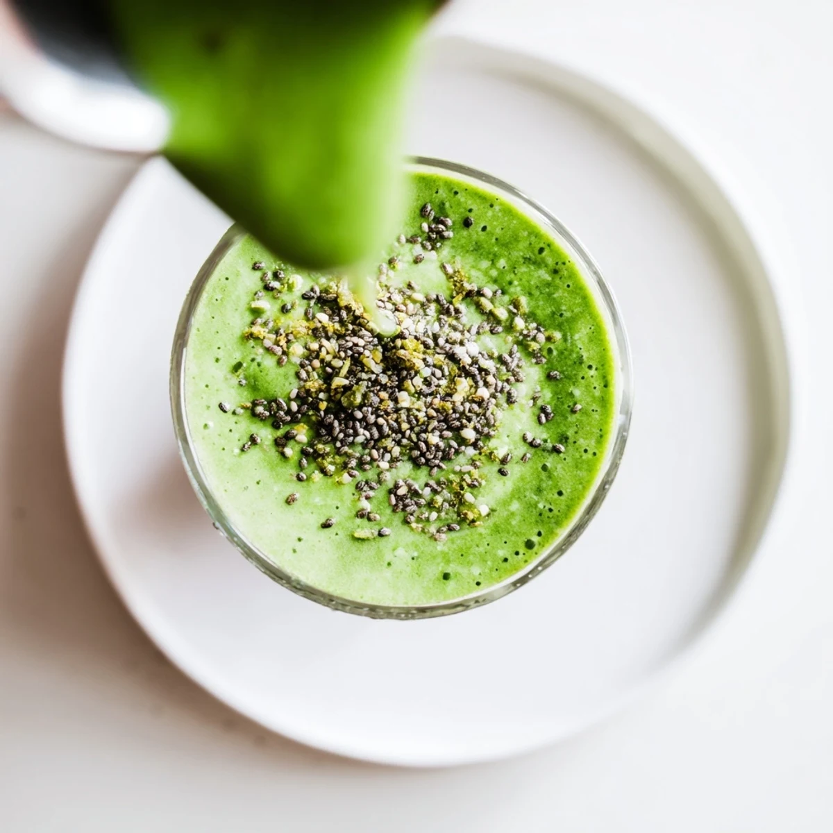 Creamy Green Detox Smoothie with Ginger poured into a tall glass, garnished with a lemon slice and chia seeds.