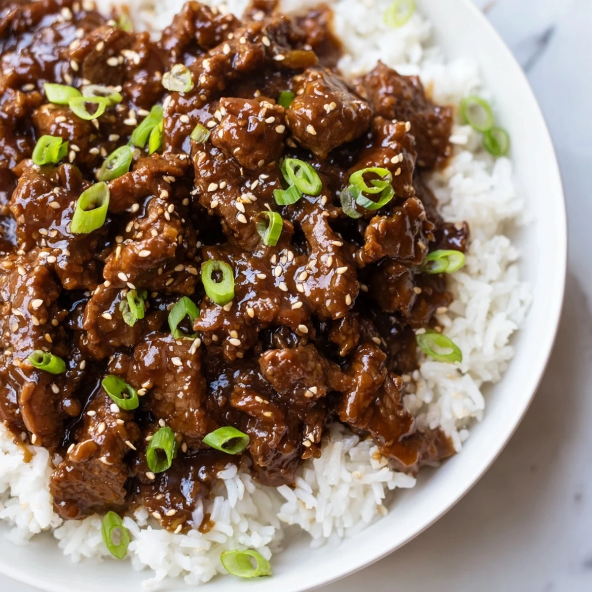 Tender shredded Crock Pot Korean Beef simmering in a rich, glossy sauce, garnished with green onions and sesame seeds.