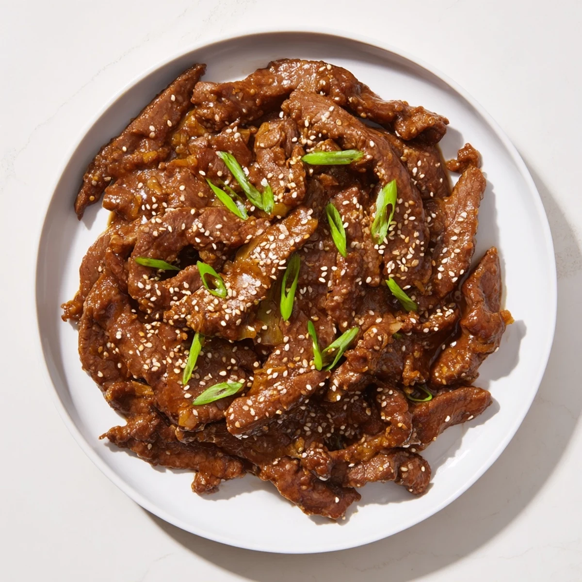 Tender beef strips in Ultimate Slow Cooker Mongolian Beef, garnished and ready to serve.