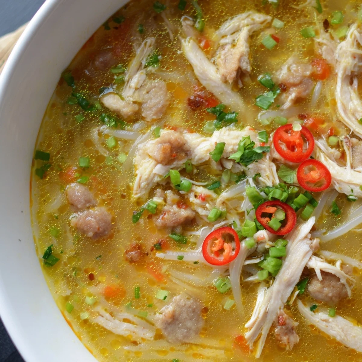 Fresh Bun Thang served with herbs, pork sausage, and lime wedges for a comforting Vietnamese noodle soup.