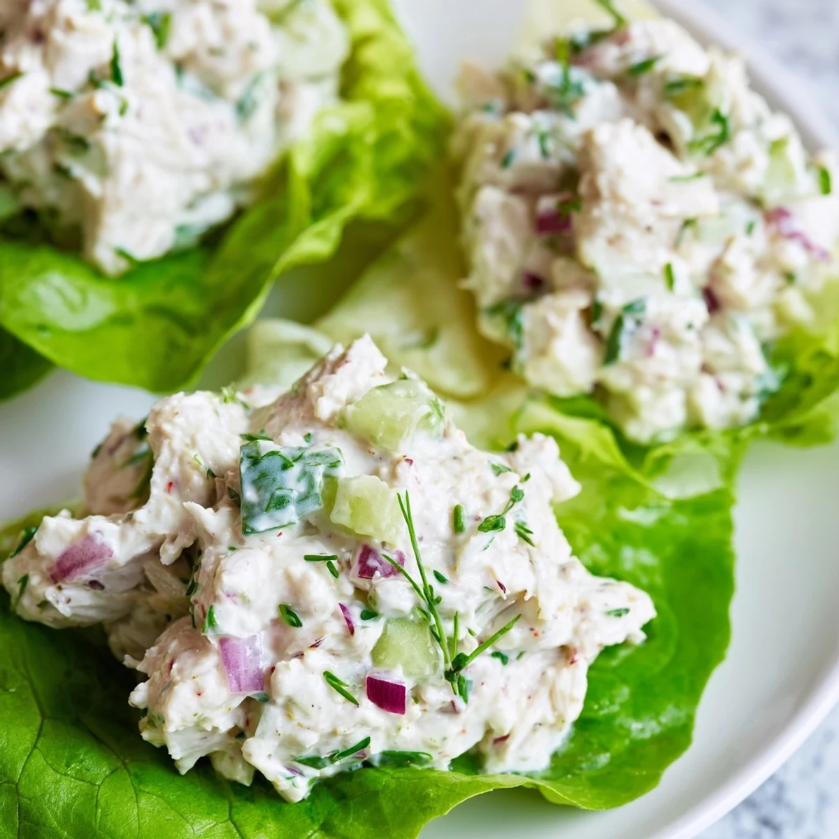 Crab salad garnished with fresh lemon wedges and chives on a bed of mixed greens.