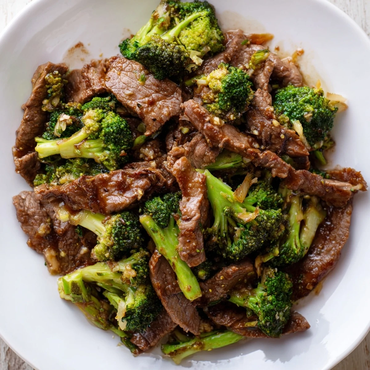 Steaming better than takeout beef with broccoli over fluffy white rice in a ceramic bowl.