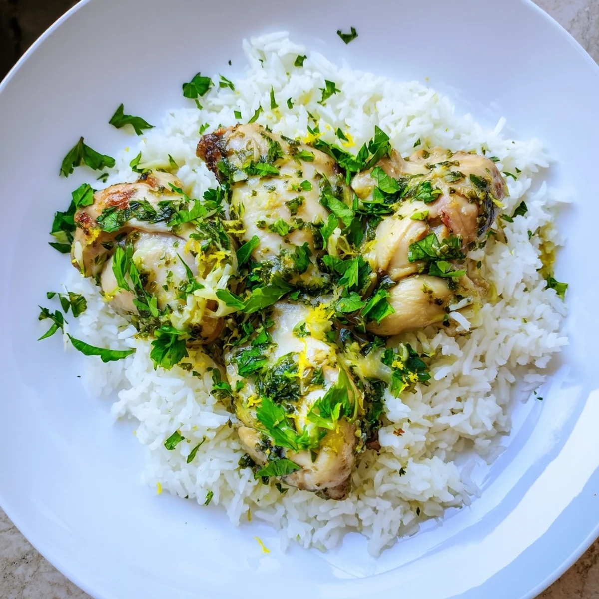 Golden Slow Cooker Lemon Herb Chicken With Fluffy Rice plated beside lemon slices and a glass of white wine