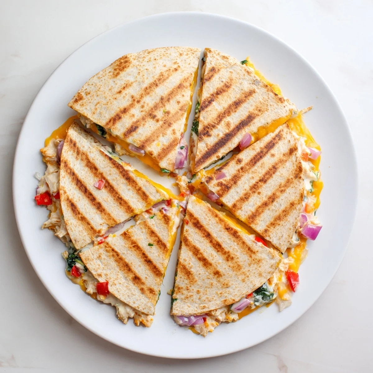 Golden brown high protein chicken ranch quesadilla sliced into wedges revealing melted cheese and colorful vegetables