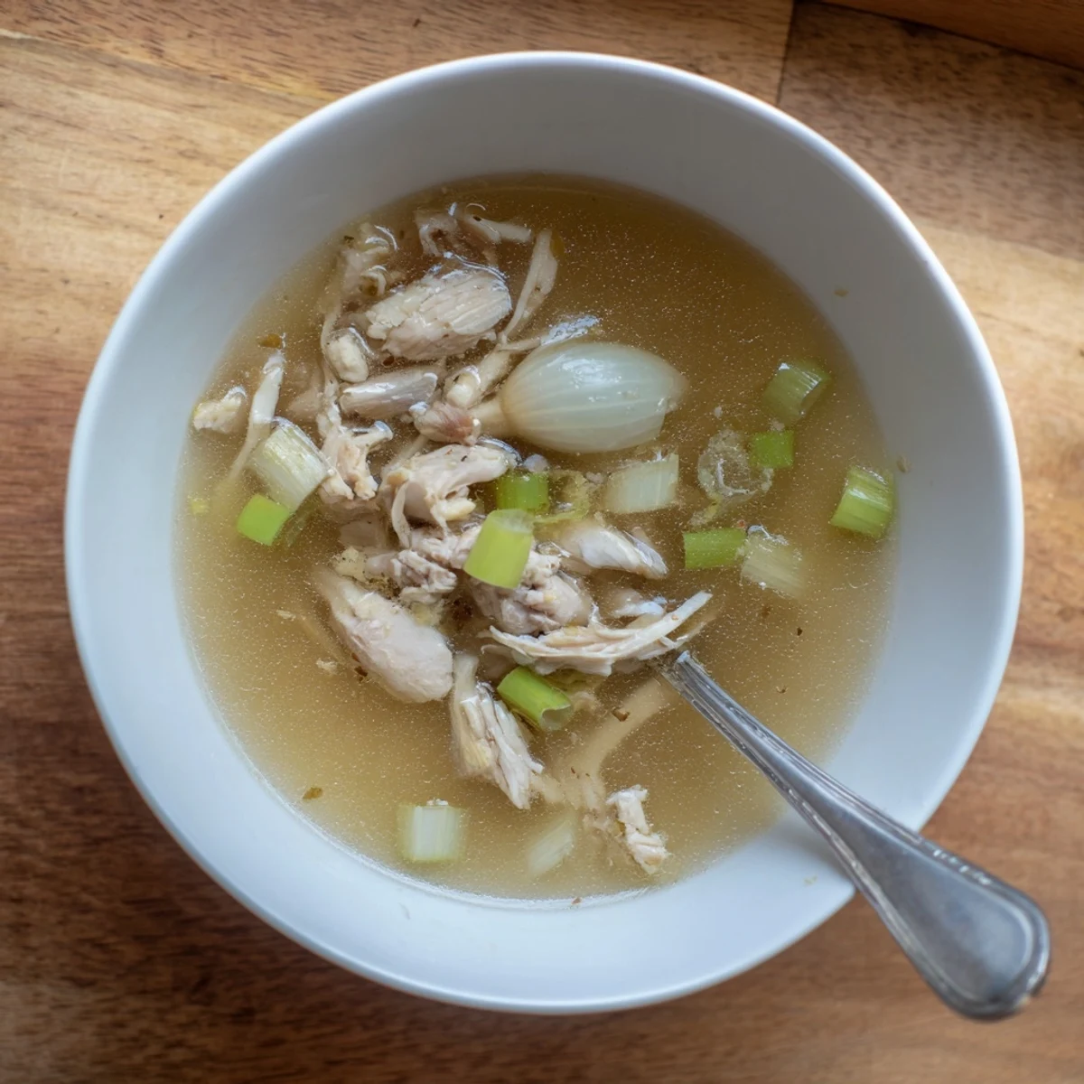 Steaming bowl of Dakgomtang Korean chicken soup garnished with fresh green onions