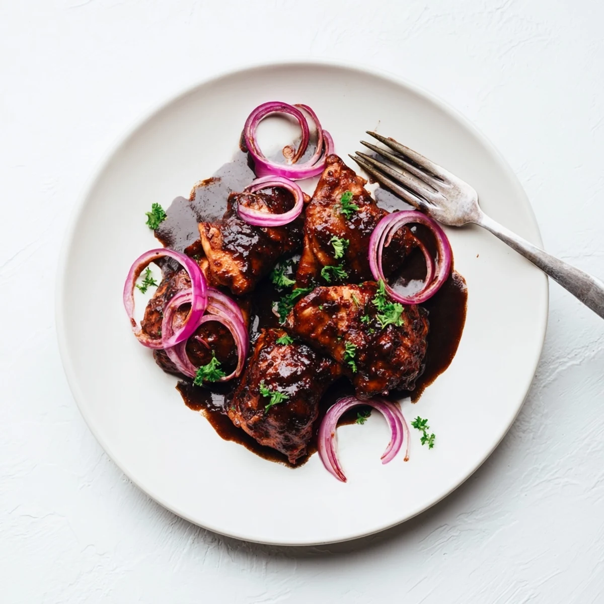 Tender slow cooker balsamic chicken thighs glazed in rich dark sauce garnished with fresh parsley