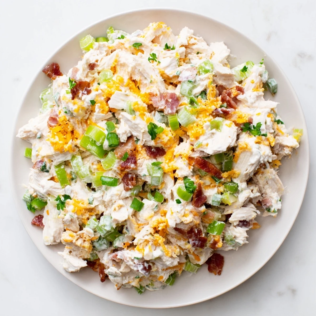 Creamy low carb jalapeno popper cottage cheese chicken salad with crispy bacon and fresh diced jalapenos in a white bowl