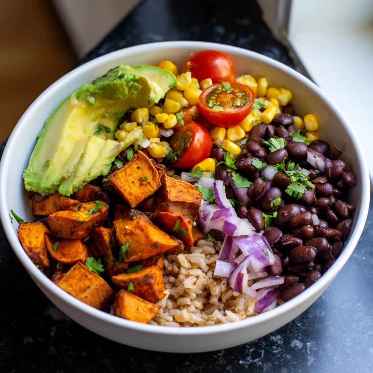 Hearty vegan sweet potato burrito bowl featuring spiced roasted potatoes brown rice and colorful vegetables