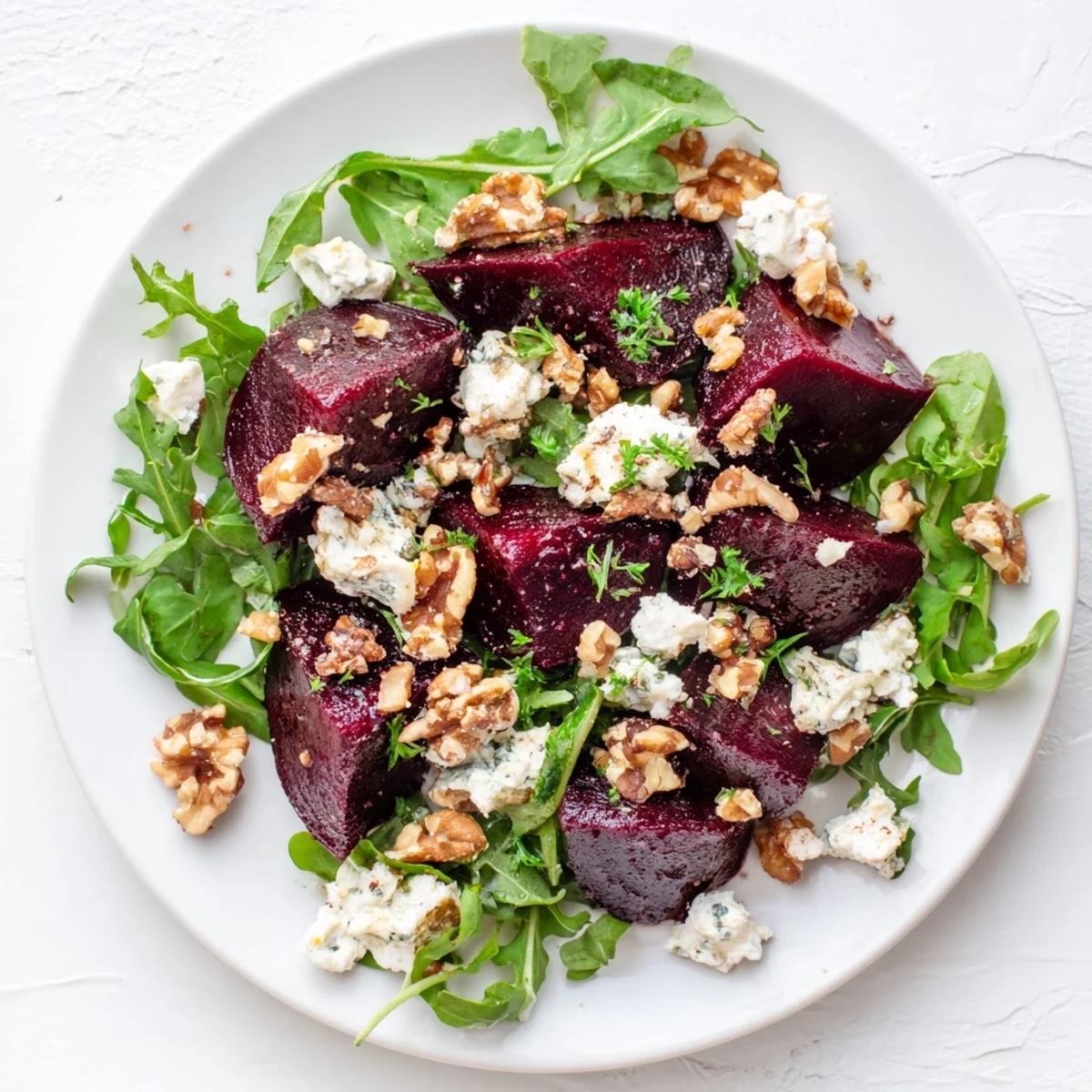 Golden roasted beet wedges scattered over fresh mixed greens with crumbled goat cheese and toasted walnuts