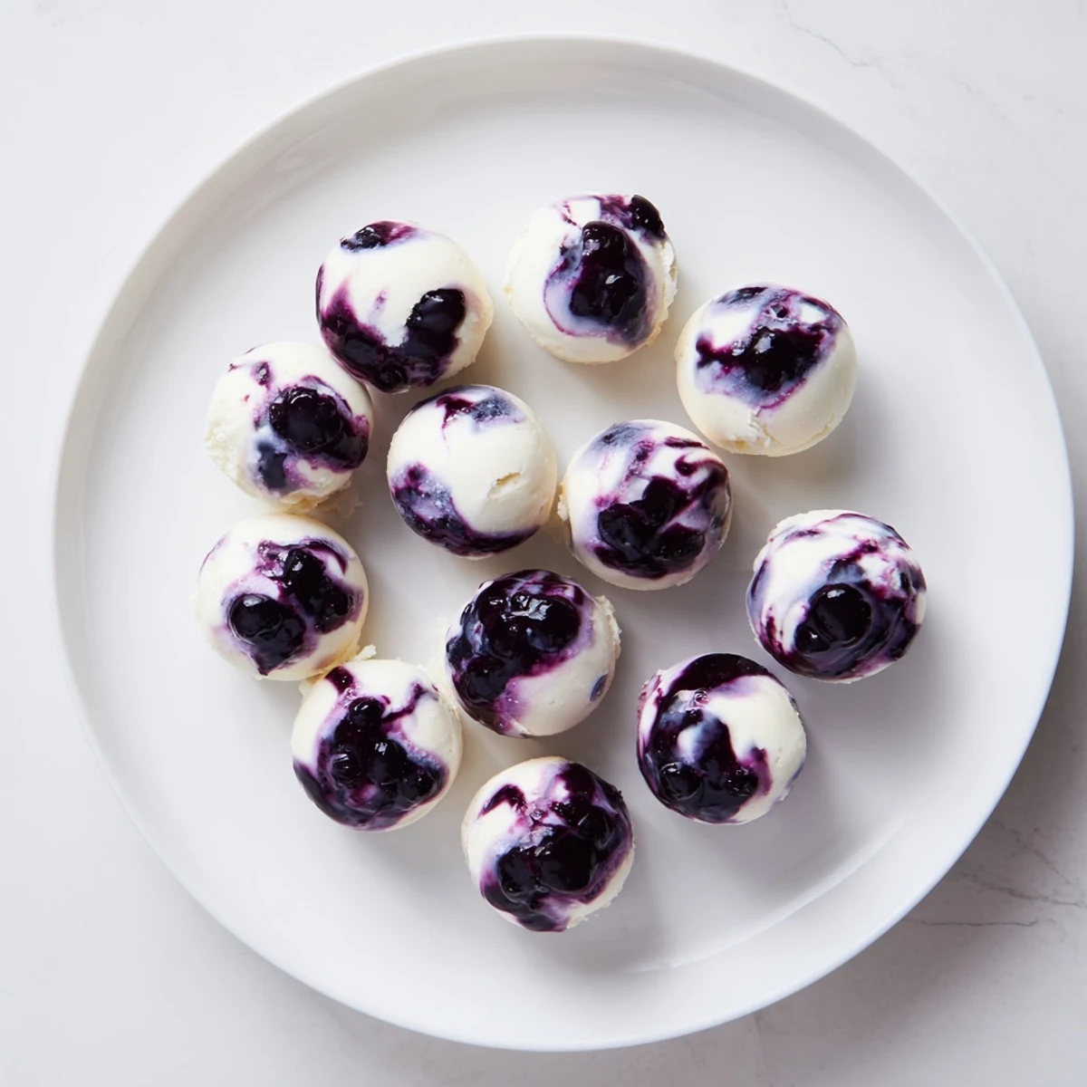 Homemade blueberry swirl yogurt bites arranged neatly in rows showcasing the vibrant blueberry compote swirled into tangy Greek yogurt