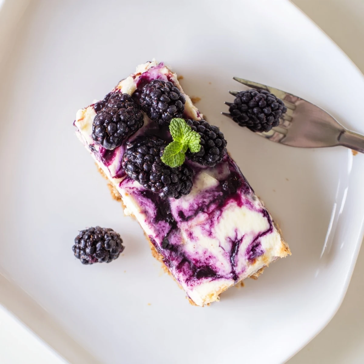 Velvety cheesecake swirled with tangy blackberry compote on golden graham cracker crust