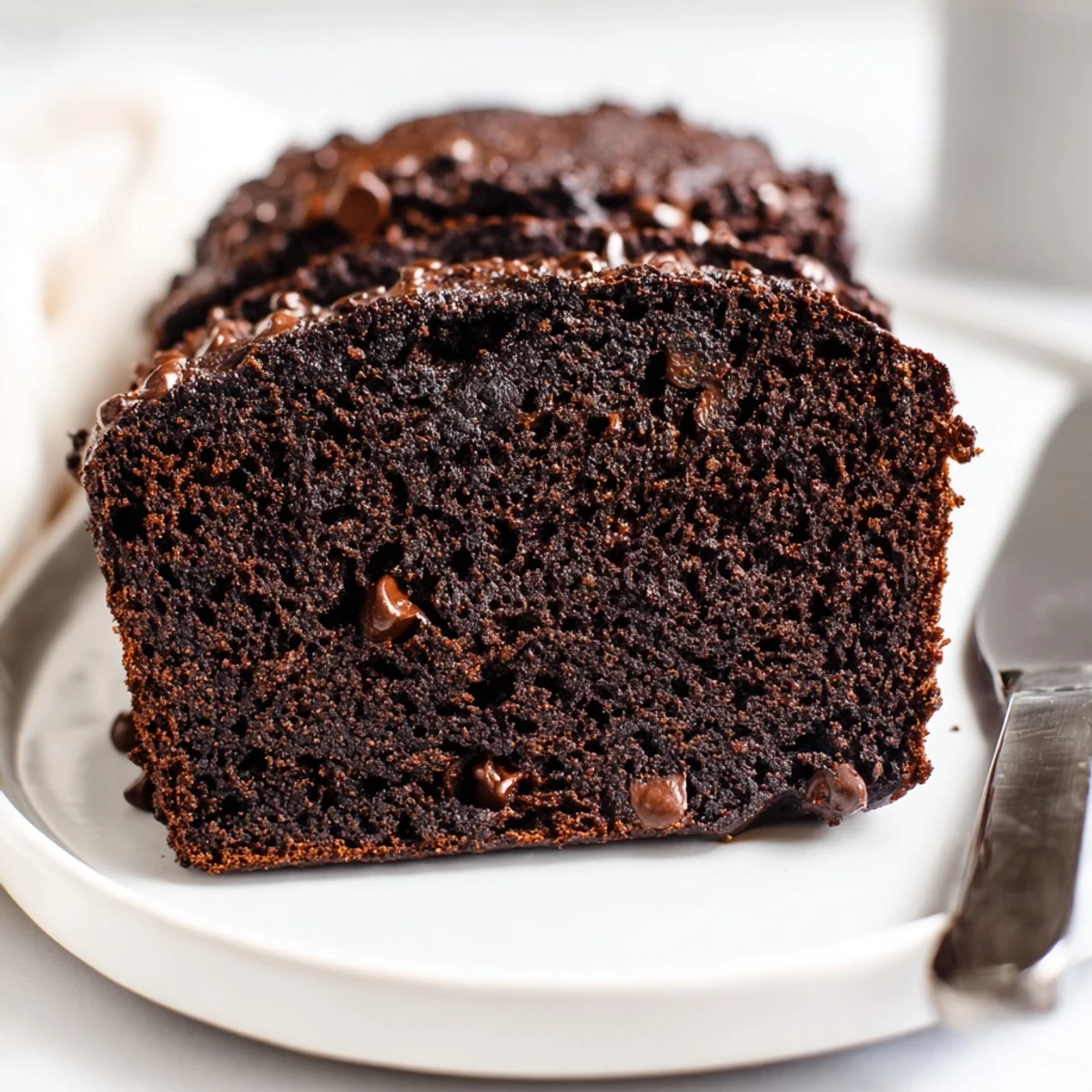 Slice of rich chocolate espresso banana bread revealing dark chocolate chunks and tender crumb