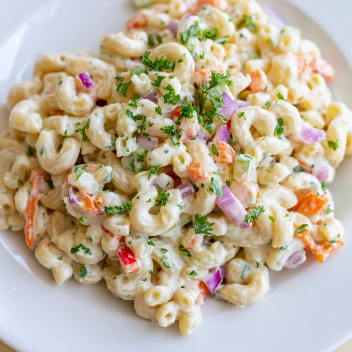 Creamy macaroni salad bowl loaded with colorful diced vegetables and tangy mayonnaise dressing