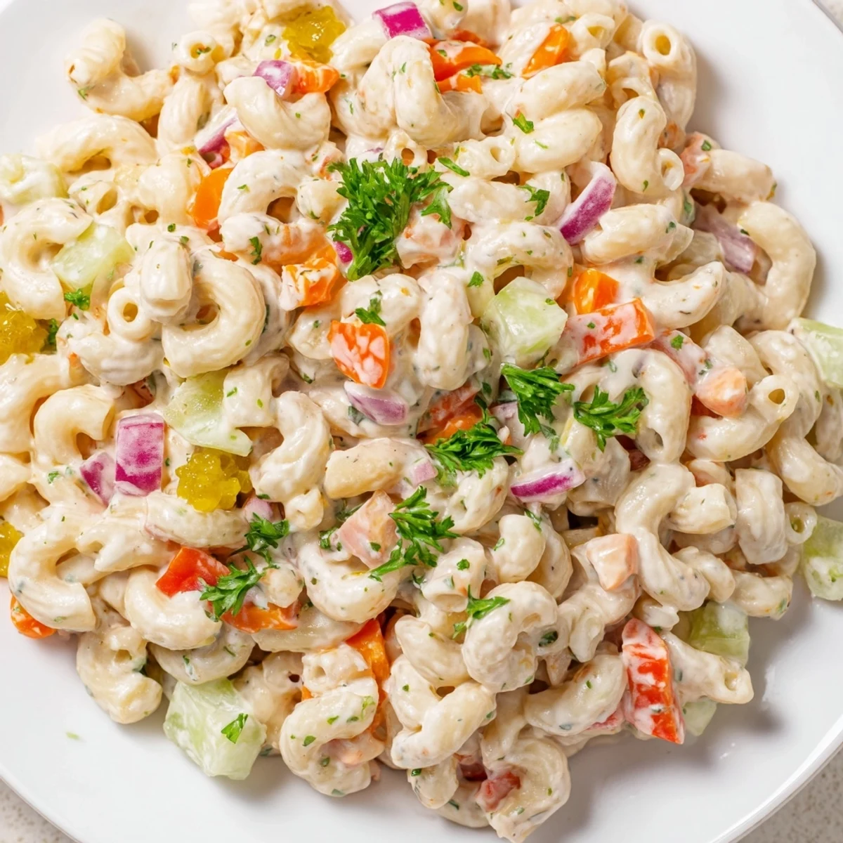 Fresh macaroni salad featuring tender pasta elbows, crunchy red bell peppers, and smooth creamy dressing