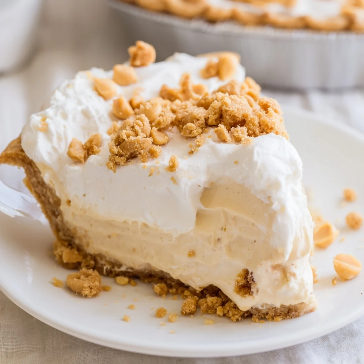 Creamy Amish Peanut Butter Dream Pie with golden peanut butter crumbs piled high on whipped topping