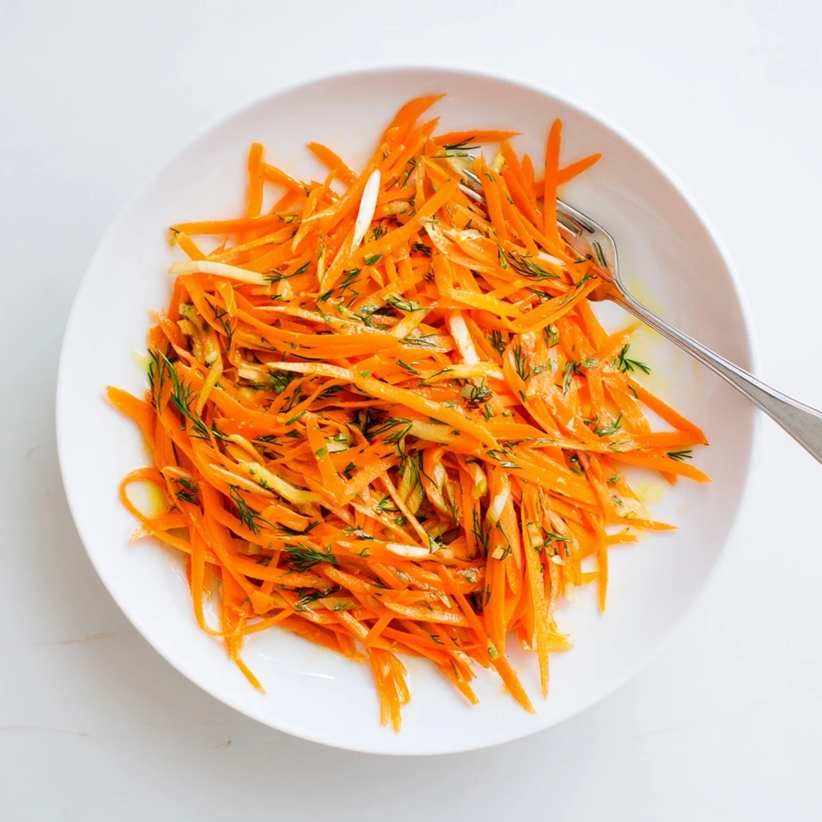 Crisp Marinated Lemon Dill Carrot Salad glistening with zesty dressing in a serving bowl