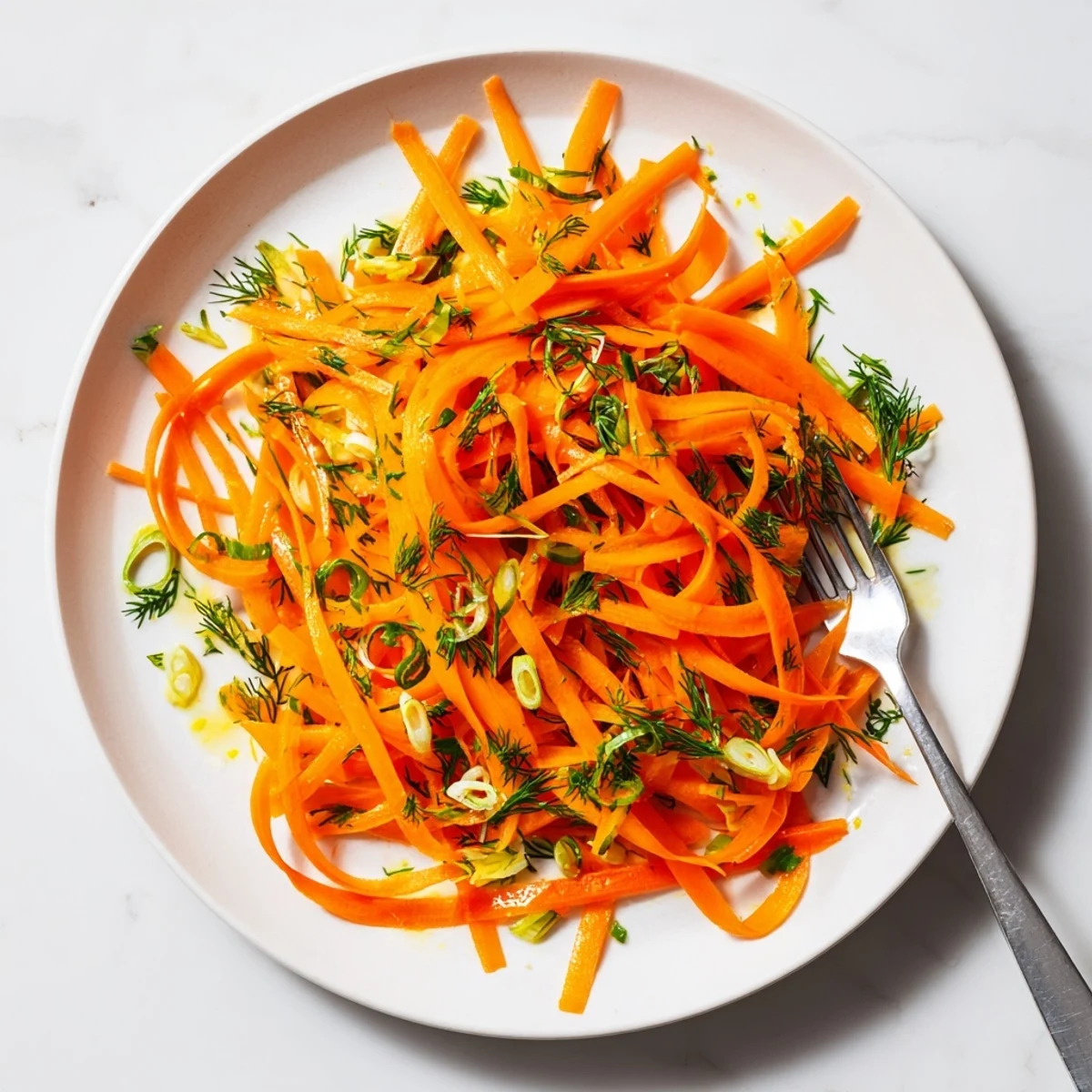 Bright orange carrots tossed in lemon dill marinade with fresh scallion garnish
