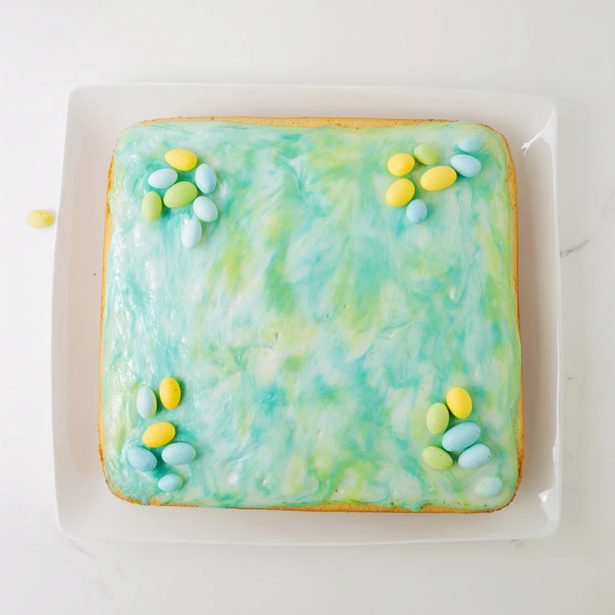 Robin Egg Snack Cake with pastel glaze and colorful candy-coated chocolates on top