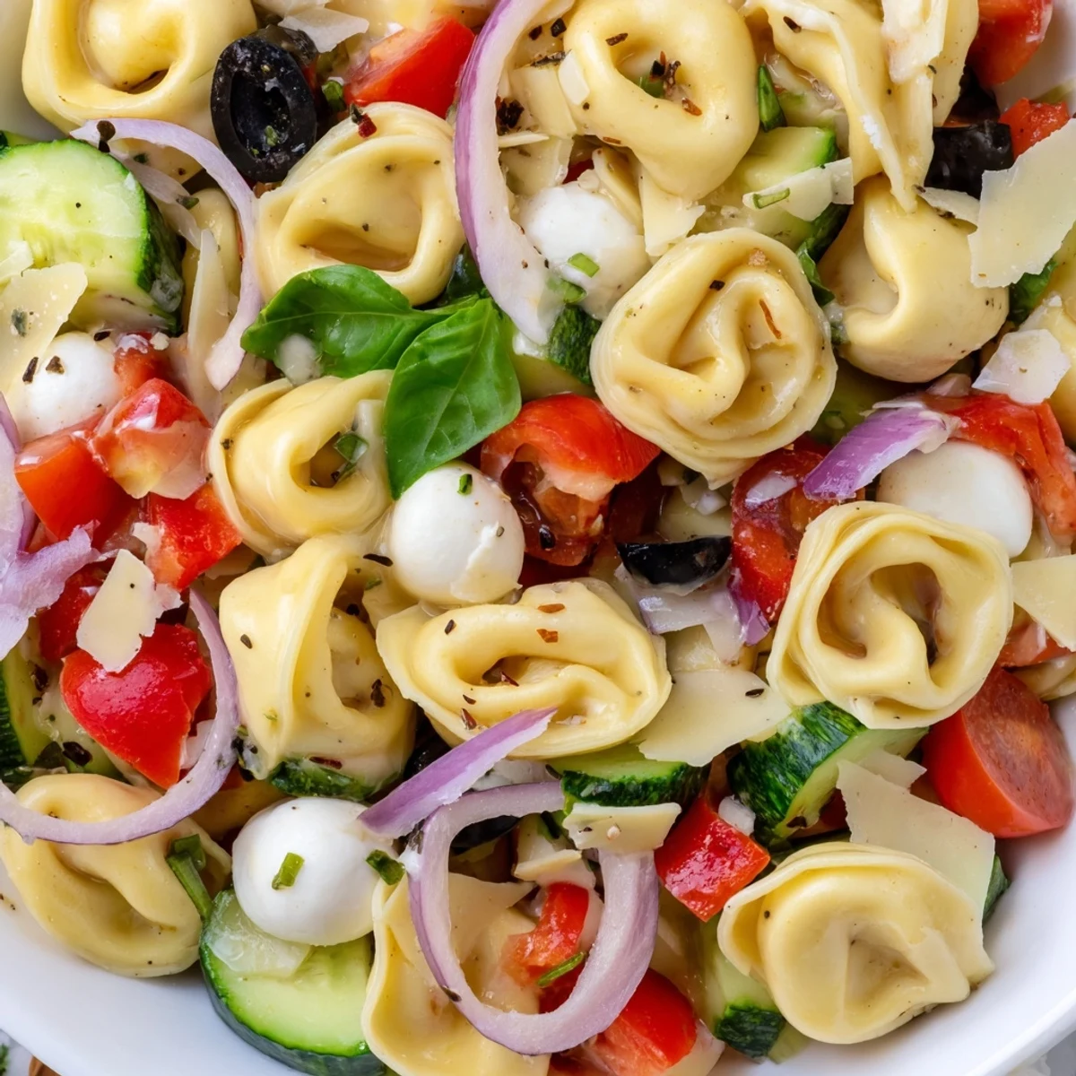 Colorful tortellini salad with cherry tomatoes, cucumber, and mozzarella tossed in zesty Italian dressing