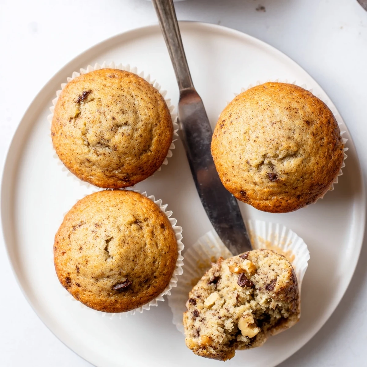 Golden banana muffins with domed tops fresh from the oven on a wire rack