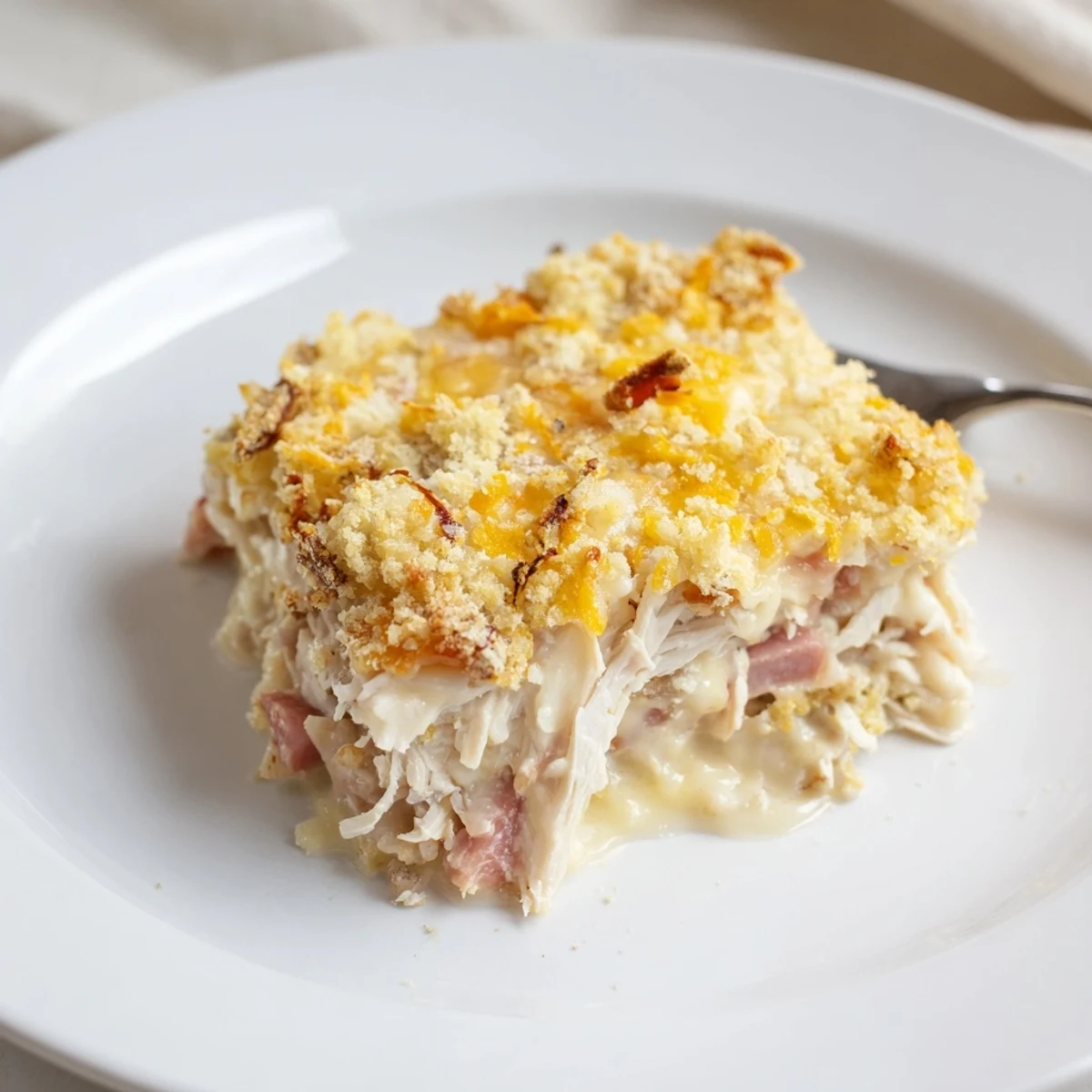 Golden bubbly Chicken Cordon Bleu Casserole with melted Swiss and crispy Parmesan topping