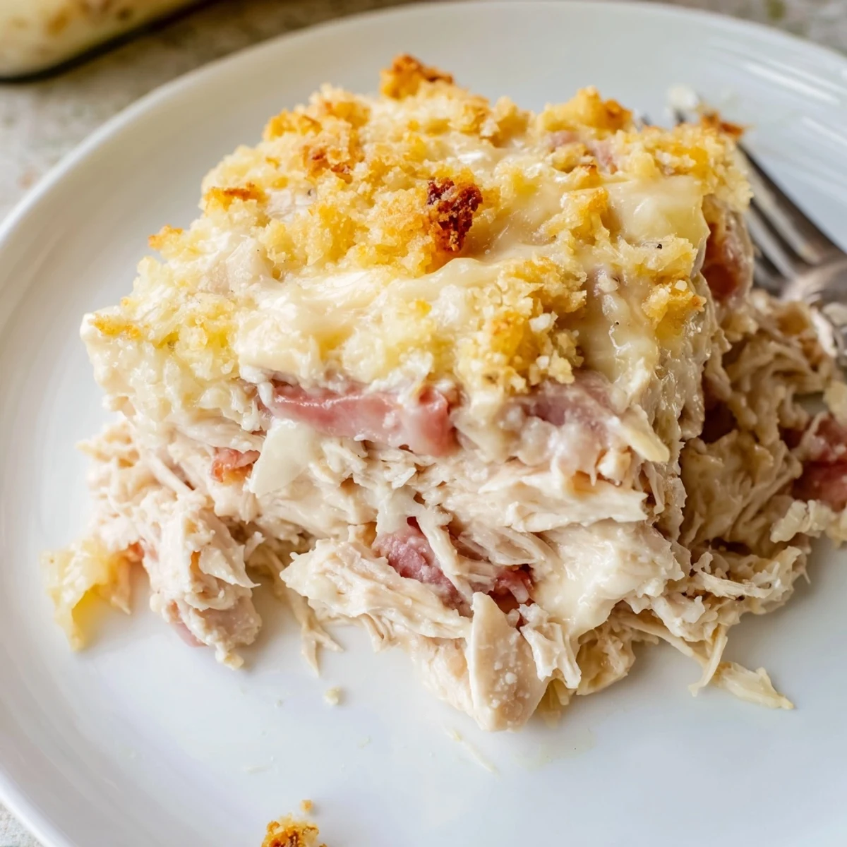 Layers of Swiss and ham in Chicken Cordon Bleu Casserole, golden and steaming