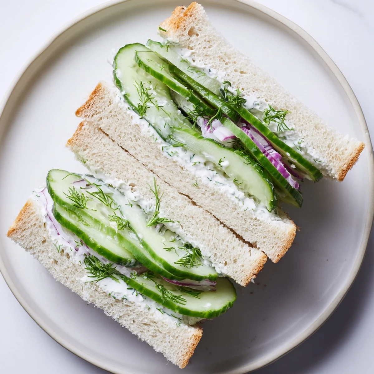 Stacked Quick Cucumber Salad Sandwiches on soft white bread, light lemony dressing