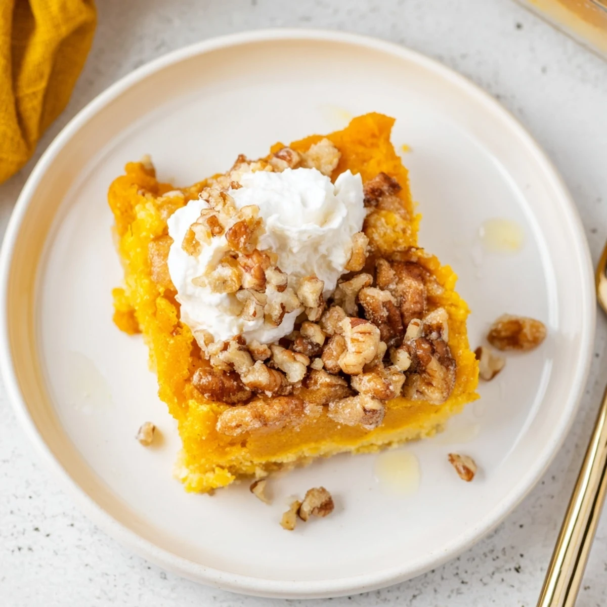 Freshly spooned Pumpkin Dump Cake in bowls, creamy pumpkin and crunchy topping