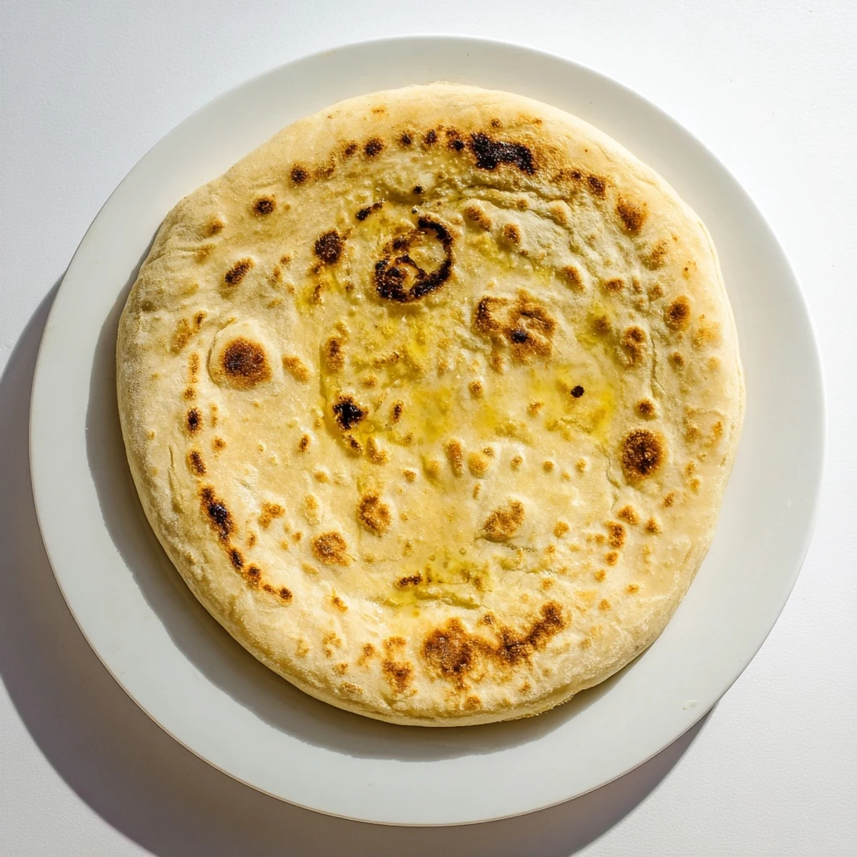 Warm Turkish Bazlama flatbread brushed with olive oil, perfect for dipping and wrapping