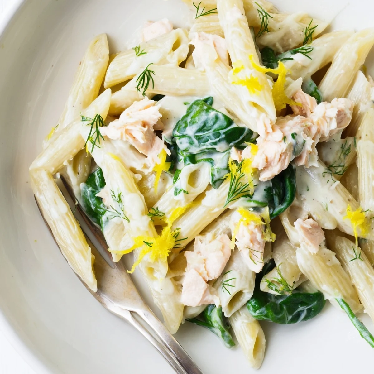 Creamy salmon penne pasta with flaky fish pieces in a rich Parmesan lemon sauce