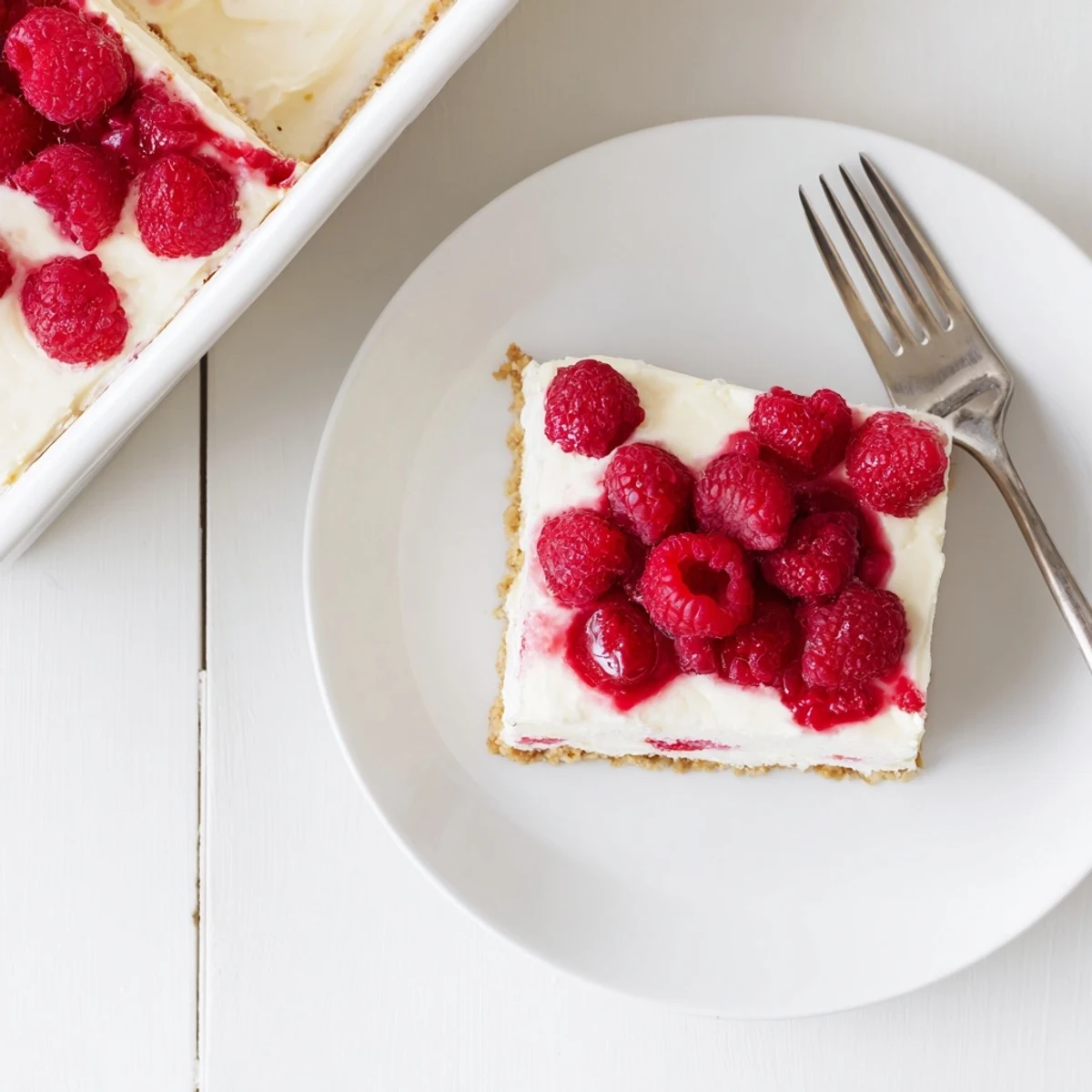 Golden graham cracker crust topped with silky vanilla cream cheese and vibrant fresh raspberries
