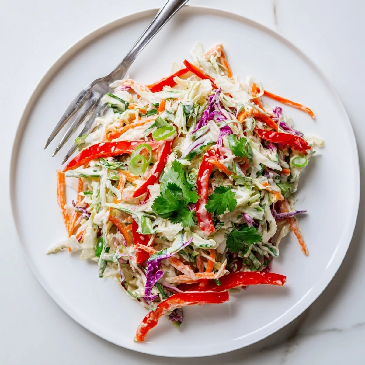 Colorful summer slaw featuring crunchy red and green cabbage mixed with shredded carrots in a creamy dressing