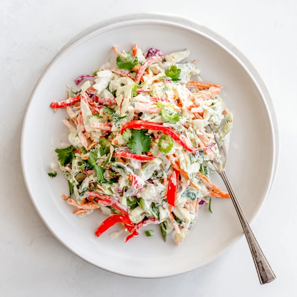 Fresh summer slaw salad with vibrant purple cabbage, crisp vegetables, and light honey-mustard dressing coating every bite
