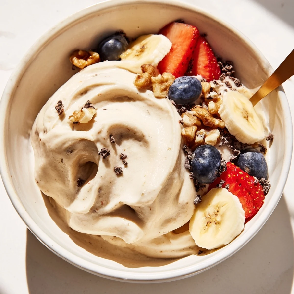 Creamy healthy nice cream recipe scooped into bowls topped with fresh berries and nuts
