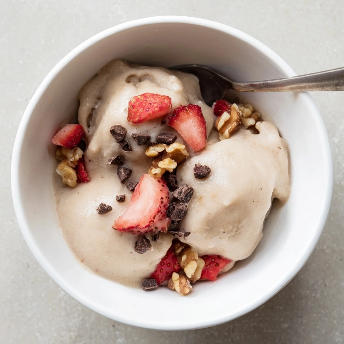 Wholesome banana nice cream dessert swirled with chocolate chips and garnished with sliced banana rounds