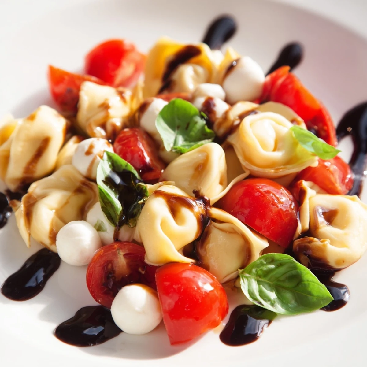 Fresh Italian Tortellini Caprese Salad featuring tender pasta pearls, juicy red tomatoes, and white mozzarella balls