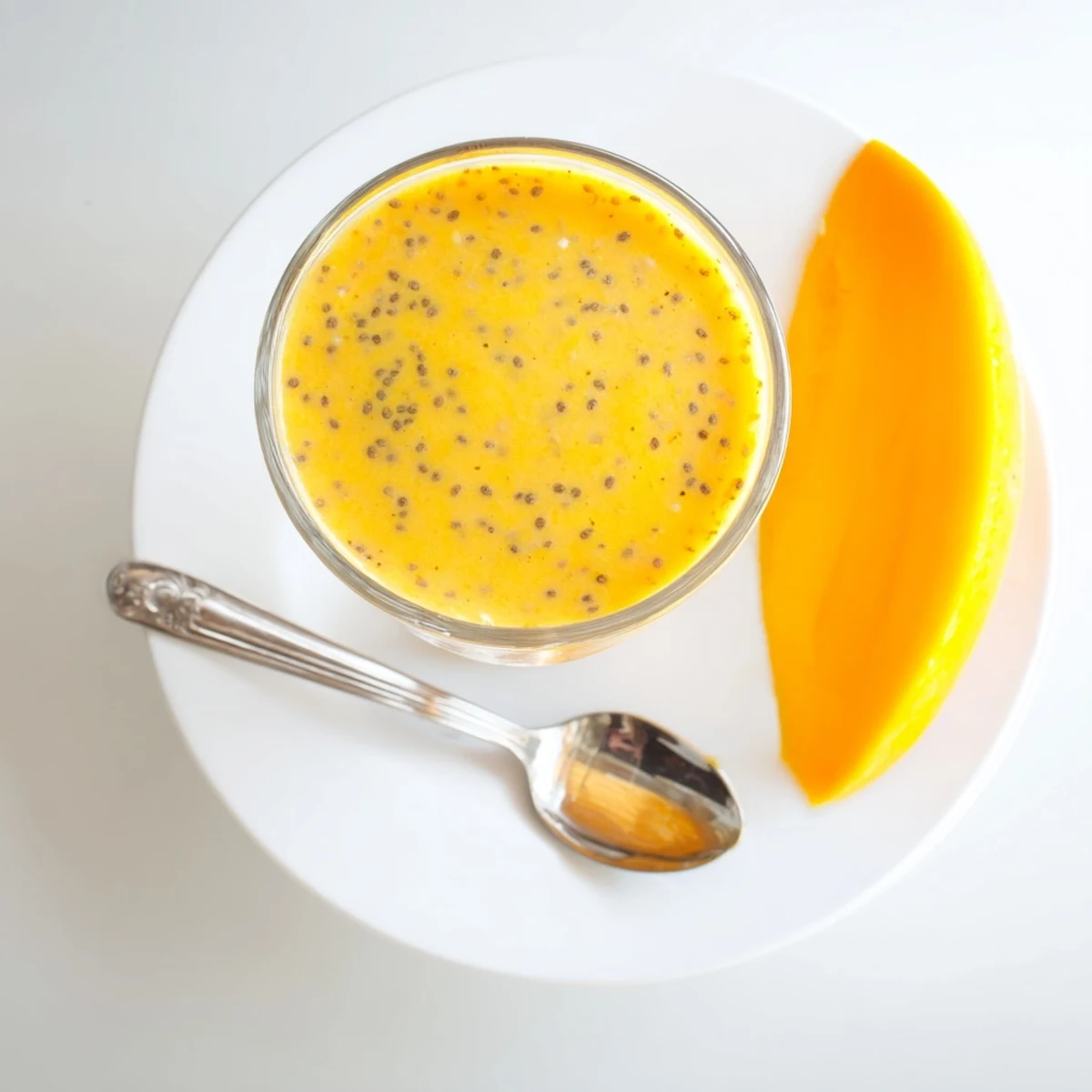 Creamy orange and pineapple protein smoothie topped with coconut and banana wheels