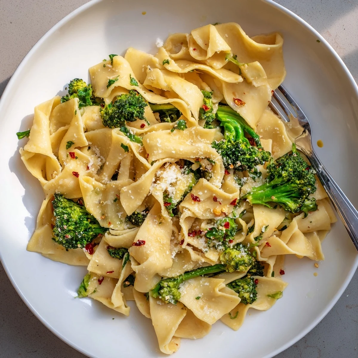 Steaming bowl of mafaldine limone broccoli pasta with vibrant green florets and zesty lemon glaze